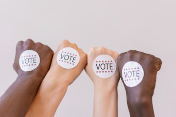 Hands with VOTE stickers